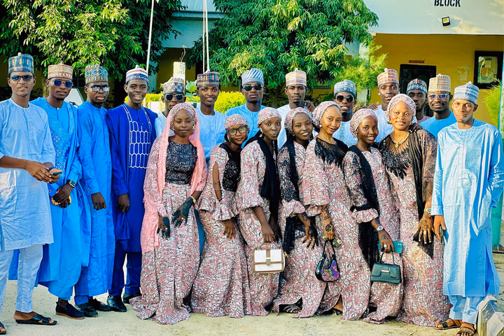 A group portrait taken outdoors likely at a school or institutional setting