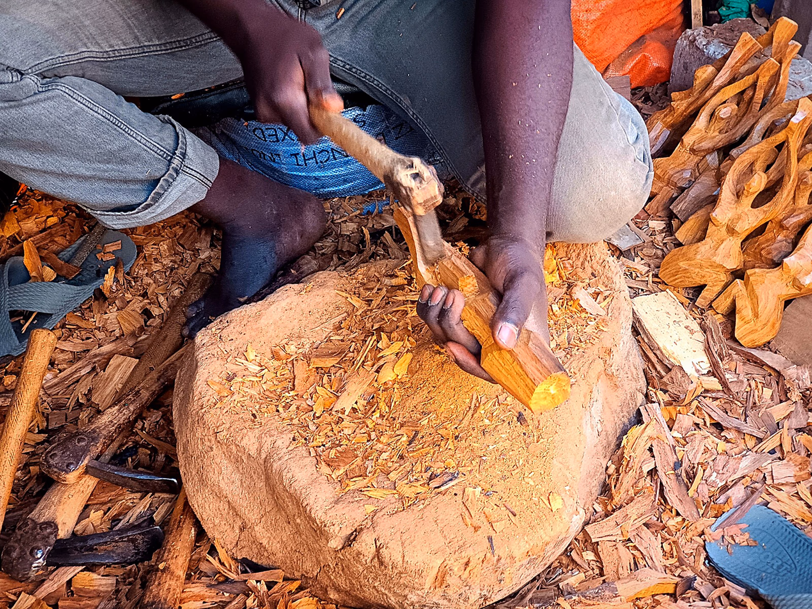 African artisan carving women shaped statuettes